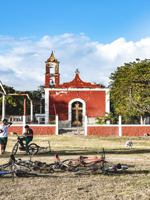 Photo d'une église mexicaine avec des enfants et leur vélo devant