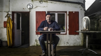 Homme assis sur une chaise, regardant devant lui