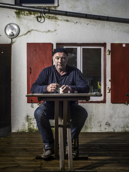 Homme assis sur une chaise, regardant devant lui